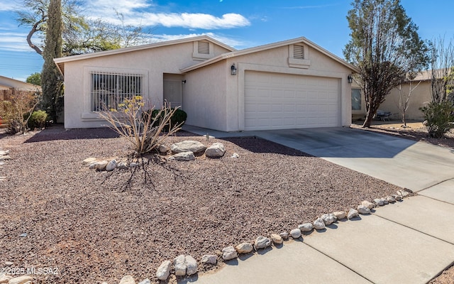 view of front of home featuring an attached garage, driveway, and stucco siding