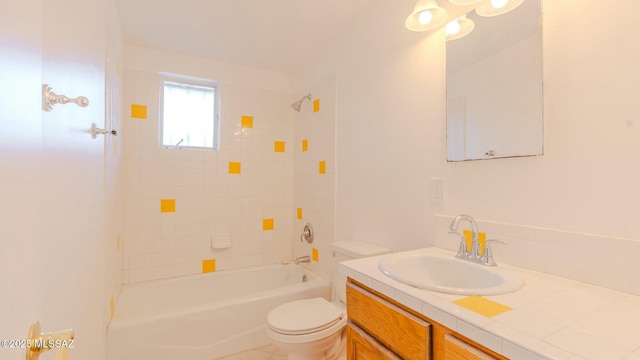 full bathroom featuring vanity, tiled shower / bath, and toilet