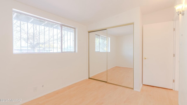 unfurnished bedroom featuring wood-type flooring and a closet