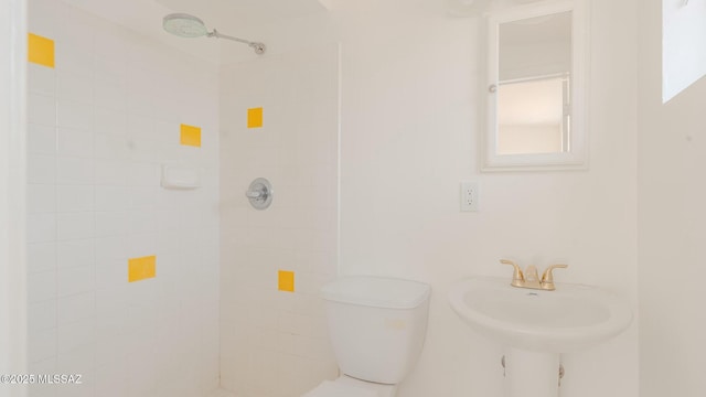 bathroom featuring a tile shower and sink