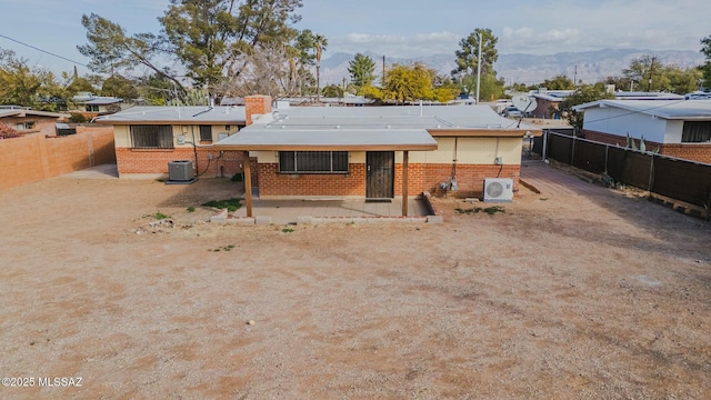 back of property with cooling unit and a mountain view