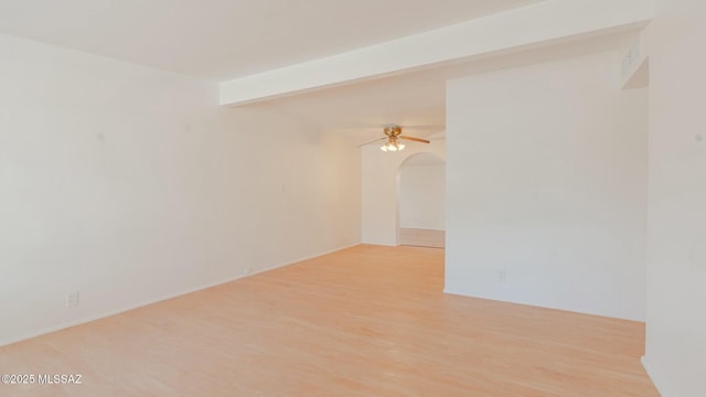 unfurnished room with beamed ceiling, ceiling fan, and light hardwood / wood-style flooring