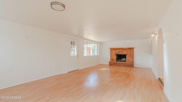 unfurnished living room with a fireplace and light hardwood / wood-style floors