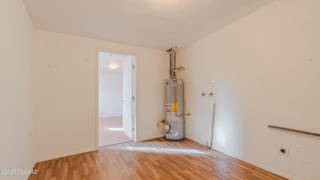 empty room featuring gas water heater and wood-type flooring