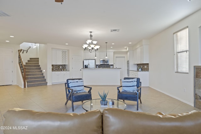 living room featuring light tile patterned flooring and an inviting chandelier