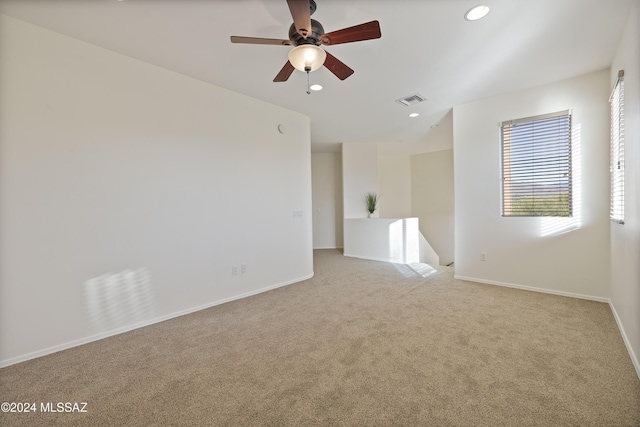 unfurnished room featuring light carpet and ceiling fan