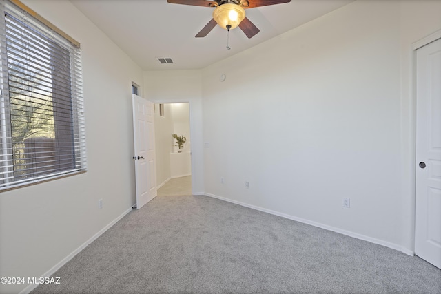 carpeted spare room featuring ceiling fan