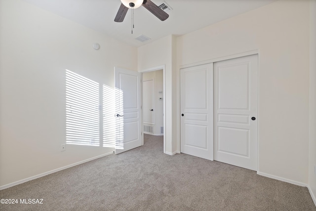 unfurnished bedroom with light carpet, ceiling fan, and a closet