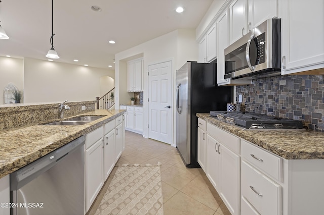 kitchen featuring stainless steel appliances, hanging light fixtures, white cabinets, and light stone counters