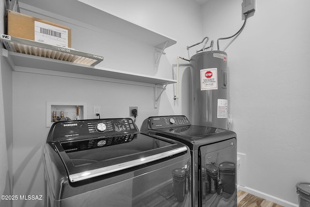 laundry area featuring washing machine and clothes dryer, electric water heater, and hardwood / wood-style floors