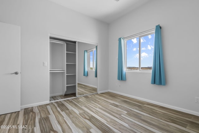 unfurnished bedroom featuring wood-type flooring and a closet