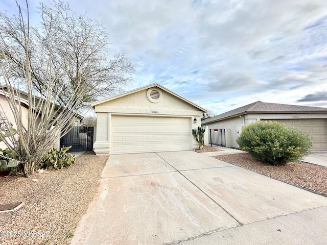 single story home featuring an outbuilding, fence, driveway, stucco siding, and a garage