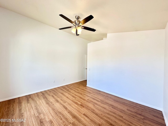 empty room with baseboards, wood finished floors, and a ceiling fan