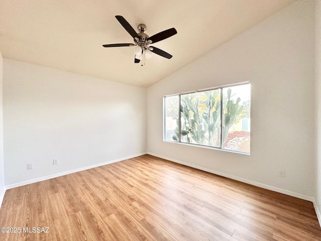 empty room with lofted ceiling, wood finished floors, baseboards, and ceiling fan