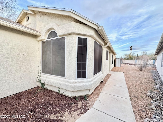 view of home's exterior featuring stucco siding and fence