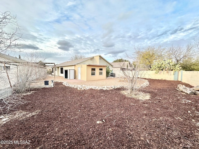 back of house featuring an outbuilding and a fenced backyard