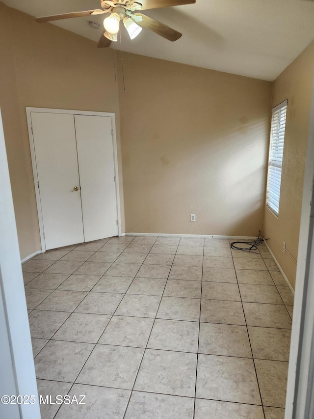 unfurnished bedroom featuring lofted ceiling, light tile patterned floors, and ceiling fan