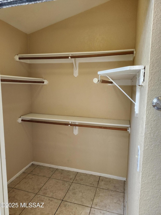 spacious closet with lofted ceiling and tile patterned flooring