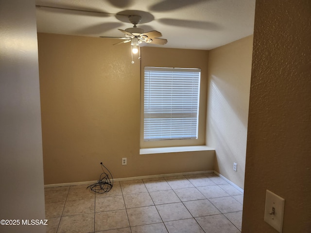 tiled spare room with ceiling fan