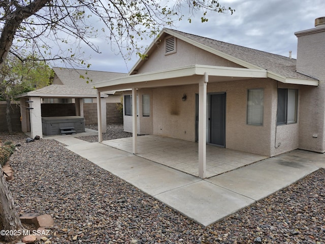 back of house featuring a hot tub and a patio