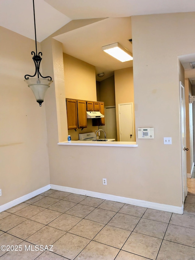 kitchen featuring vaulted ceiling, hanging light fixtures, and light tile patterned floors