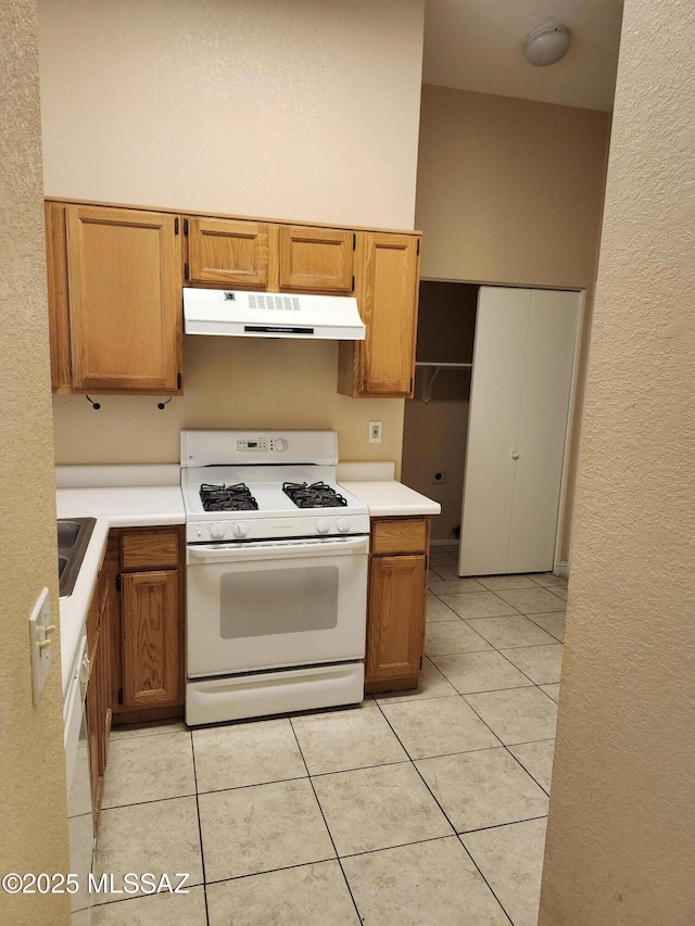 kitchen featuring white appliances, sink, a high ceiling, and light tile patterned floors
