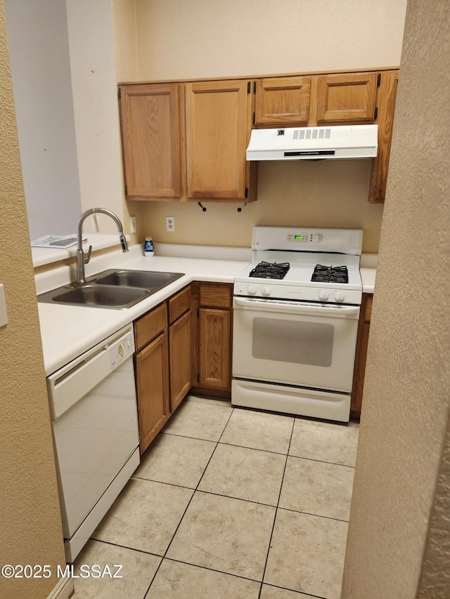 kitchen with light tile patterned flooring, white appliances, and sink