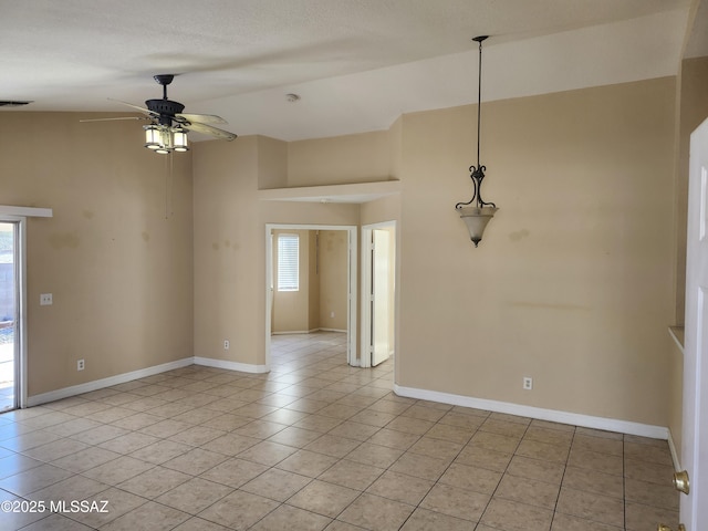 spare room featuring ceiling fan, lofted ceiling, a textured ceiling, and light tile patterned floors