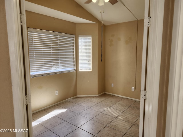 tiled spare room with vaulted ceiling and ceiling fan
