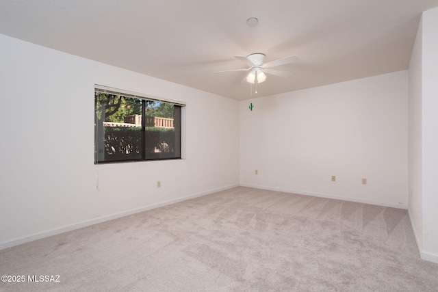 empty room featuring carpet floors, baseboards, and a ceiling fan