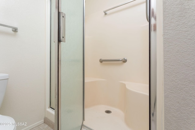 bathroom with a shower stall and toilet