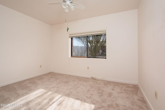 spare room with carpet floors, baseboards, and a ceiling fan