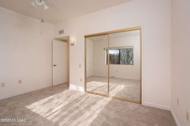 unfurnished bedroom with a closet, visible vents, a ceiling fan, carpet flooring, and baseboards