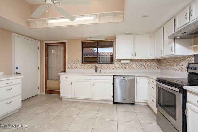 kitchen with tasteful backsplash, white cabinets, stainless steel appliances, light countertops, and light tile patterned flooring