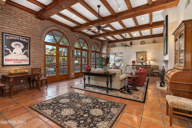 living room with a towering ceiling, tile patterned floors, french doors, and beamed ceiling