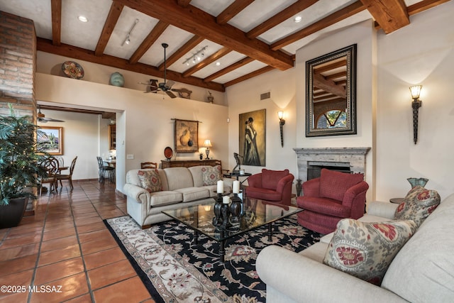 living room with beamed ceiling, ceiling fan, and tile patterned flooring