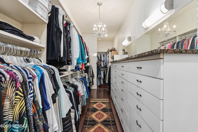 walk in closet with dark hardwood / wood-style flooring and a chandelier