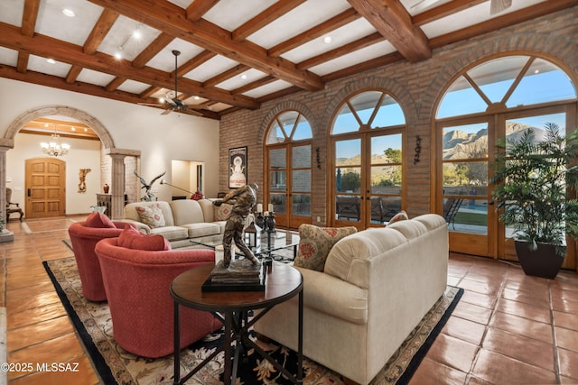 living room with beamed ceiling, plenty of natural light, a mountain view, and french doors