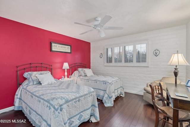 bedroom with brick wall, dark hardwood / wood-style floors, and ceiling fan