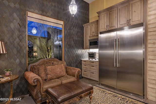 kitchen featuring a toaster, light countertops, and built in appliances