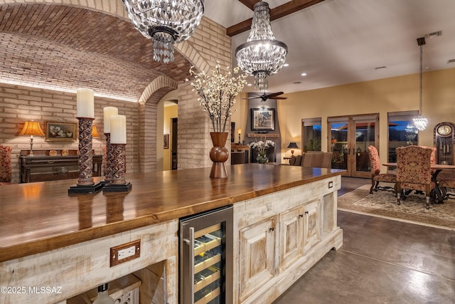 bar with wine cooler, brick wall, brick ceiling, decorative light fixtures, and finished concrete floors