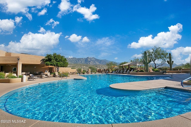 view of swimming pool featuring a patio and a mountain view