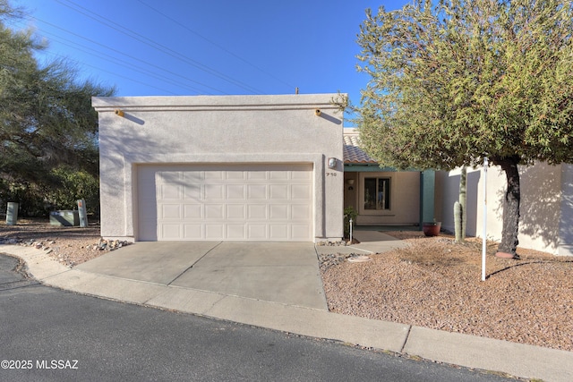 view of front of home featuring a garage, driveway, and stucco siding