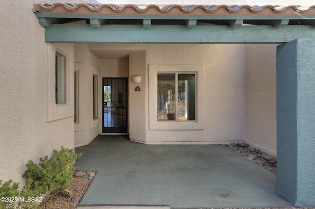 doorway to property with a patio area and stucco siding