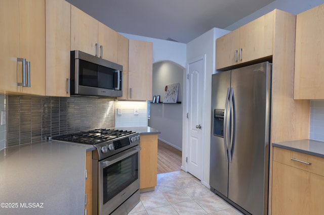 kitchen with tasteful backsplash, appliances with stainless steel finishes, and light brown cabinetry