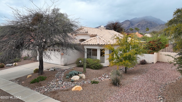 view of front of house with fence, an attached garage, stucco siding, concrete driveway, and a tiled roof