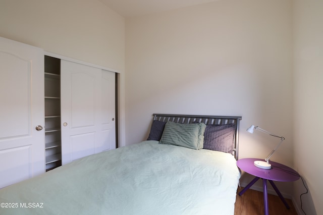 bedroom with wood finished floors and a closet