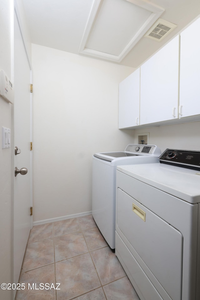 clothes washing area with independent washer and dryer, light tile patterned floors, cabinet space, and visible vents