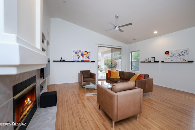 living room featuring light wood-style flooring, a ceiling fan, recessed lighting, a fireplace, and baseboards