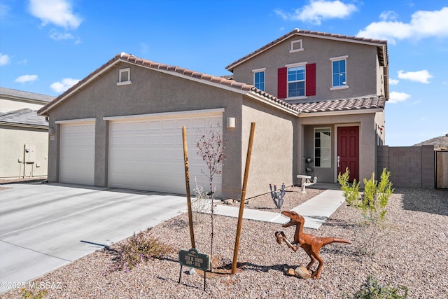 view of front facade featuring an attached garage, fence, a tile roof, concrete driveway, and stucco siding